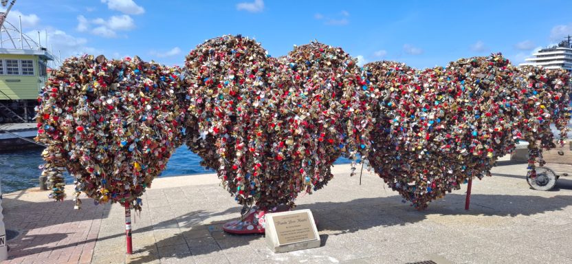 A large, abstract sculpture made of colourful padlocks arranged in heart shapes.