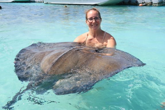 Jodie in shallow water interacting with a large stingray.